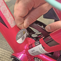 Applying bike index sticker to seat tube of bike